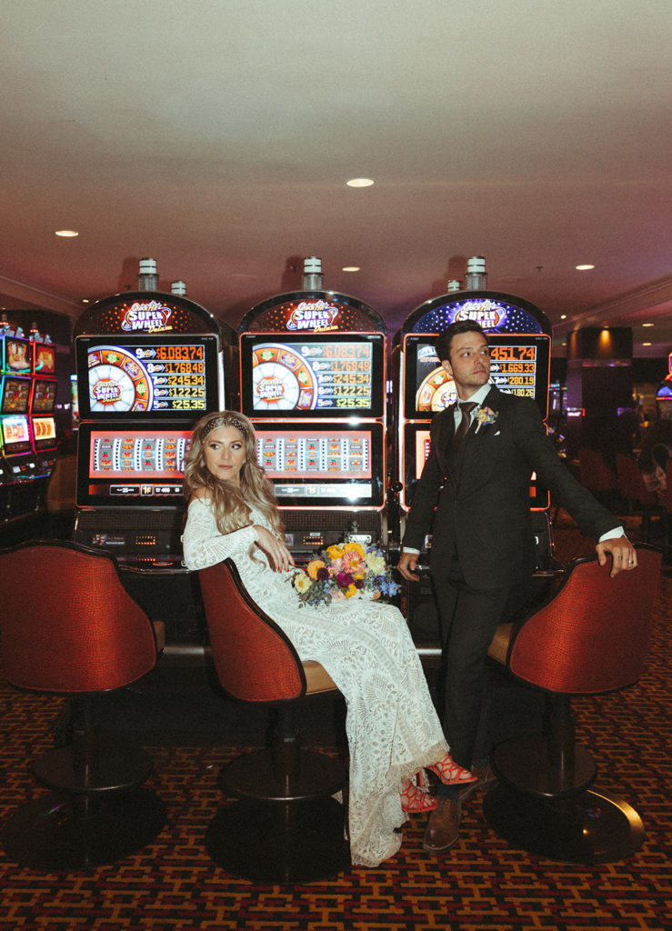 Retro & Colorful Micro-Wedding at the Doyle. Newlyweds sit at slot machines in Las Vegas casino