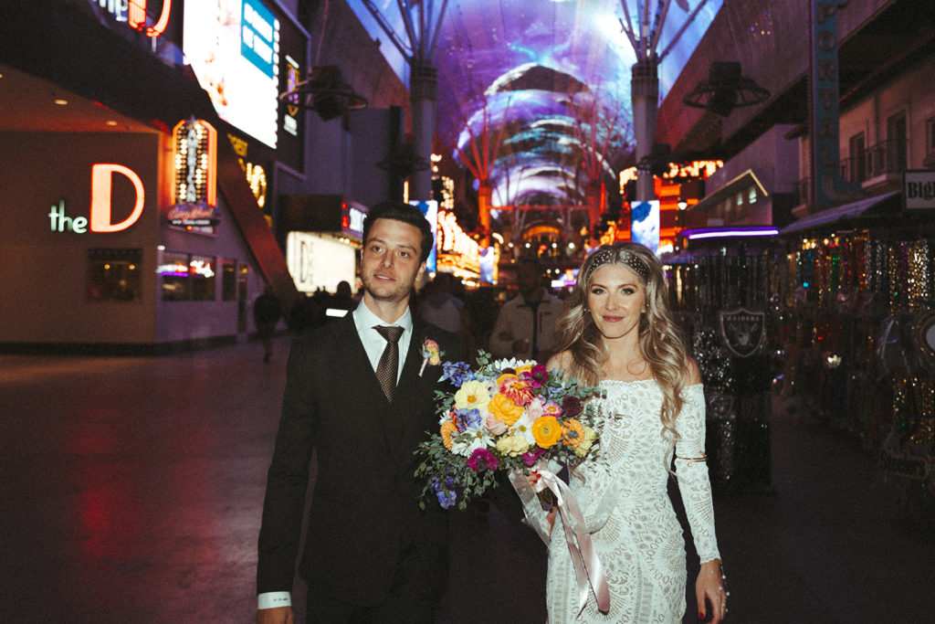 Newlyweds standing right in the middle of freemont street in downtown Las Vegas