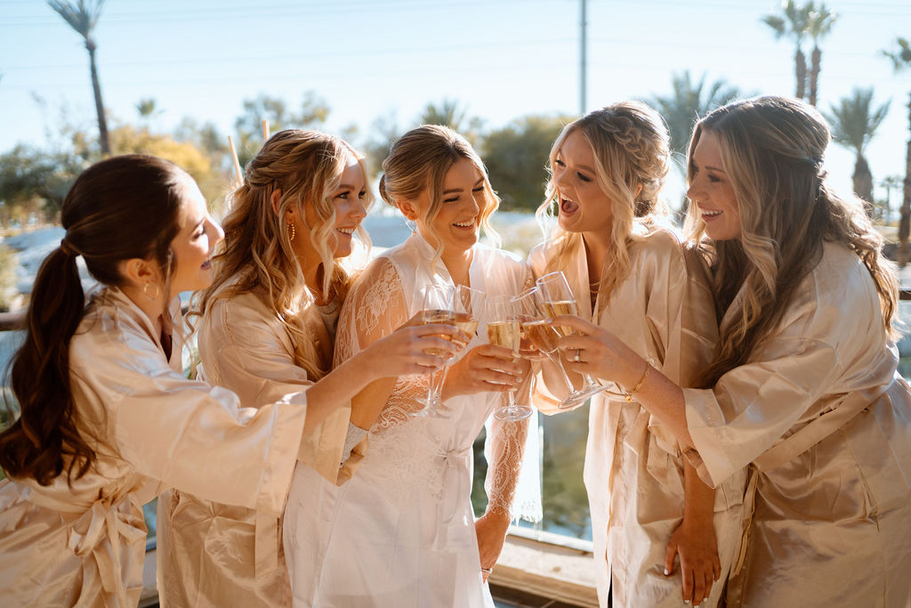 Bridesmaids clinking their glasses and drinking champagne