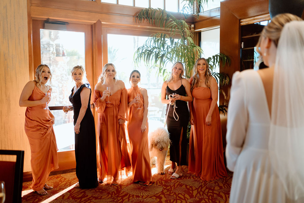 Bridesmaids turning to see bride in her wedding dress for the first time. 