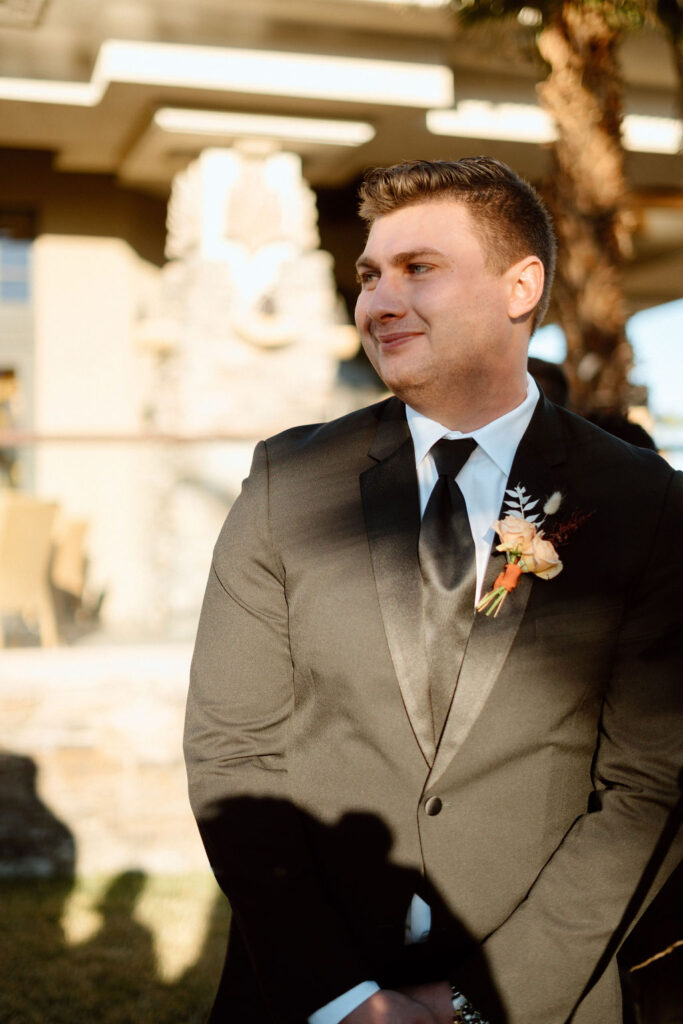 Groom is watching his bride walk down the isle and his emotions are easily seen as he watches his beautiful bride. 