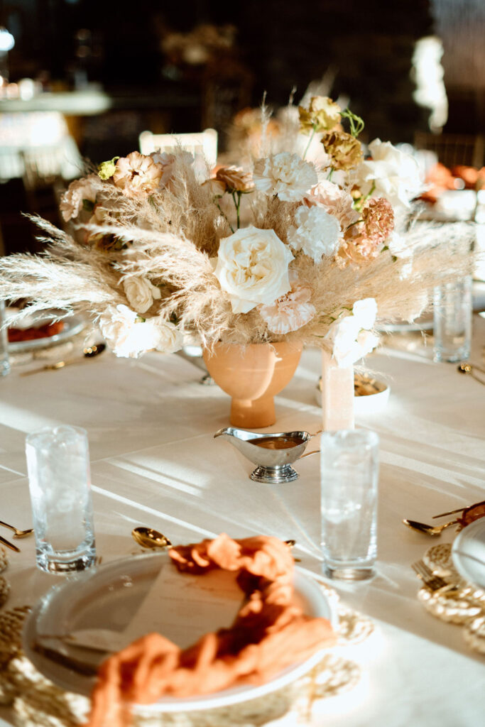 Reception boho table decor. With floral center piece and marble stone table number. 