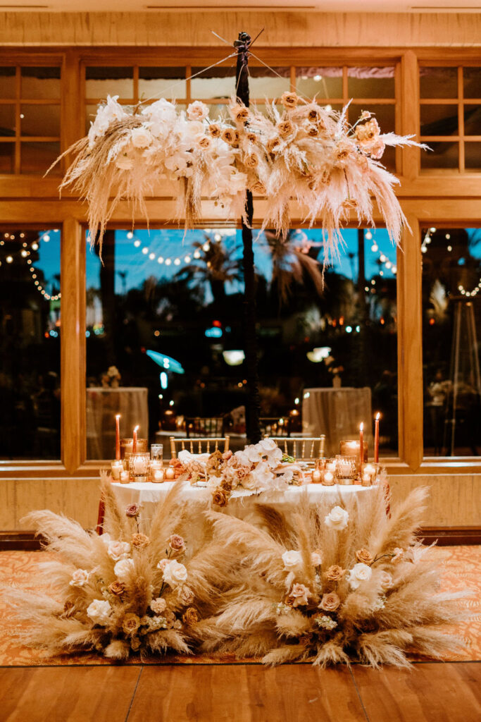 Bali Hai Boho Wedding sweetheart table with giant floral ground arches decorating the front and a hanging ceiling floral arch. 