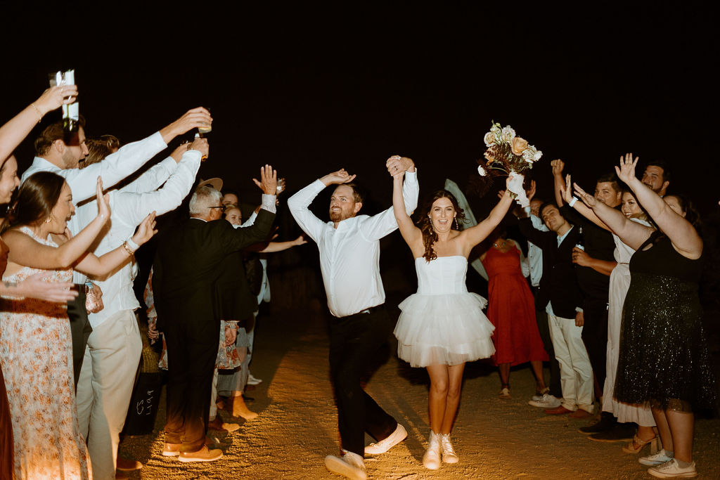 Bride and groom dancing through their final exit with their guests. 