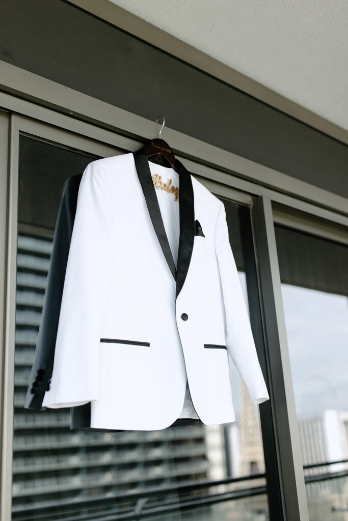 The grooms jacket hanging outside the sliding doors of the hotel suit 