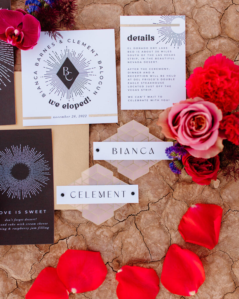 Colorful & Romantic Elopement on the Dry Lake. Stationary detail photo of the bride and grooms name card, details, and a "we eloped" card surrounded in bright florals 