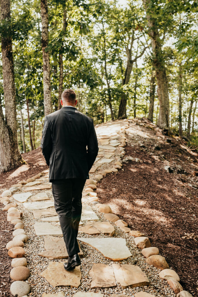 Groom walking to the knoll at the magnolia venue 