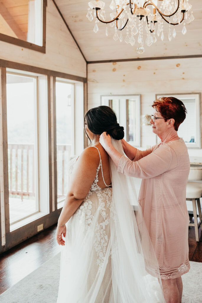 Grandmother of the bride placing the veil in the brides hair 