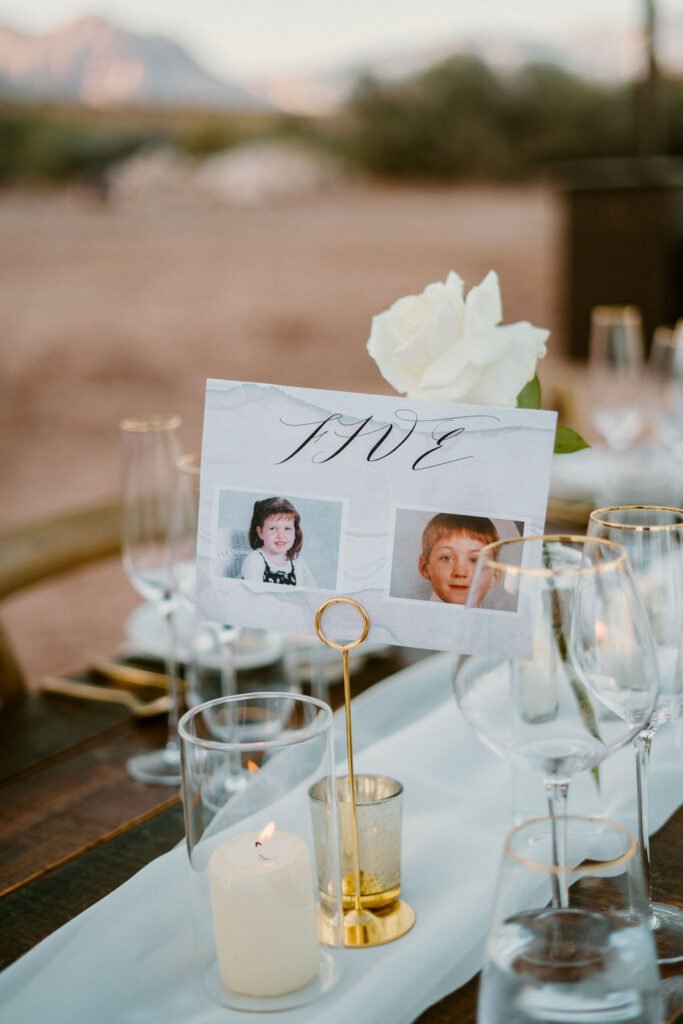 Couple showing photos of their younger selves for table decoration. 