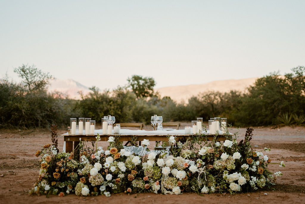 Timeless Red Rock Canyon Wedding His and Her table with ground floral arch. 