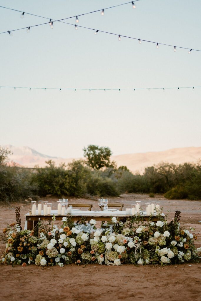 Timeless Red Rock Canyon Wedding full shot of the His and Her table with the ground floral arch. 