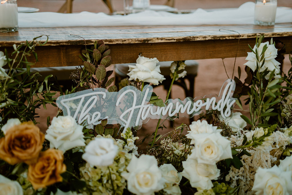 Timeless Red Rock Canyon Wedding with a hanging light sign of the couples last name. Decorated with white and toffee roses. 