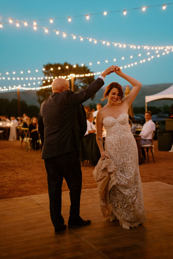 Father twirls his daughter around as she smiles