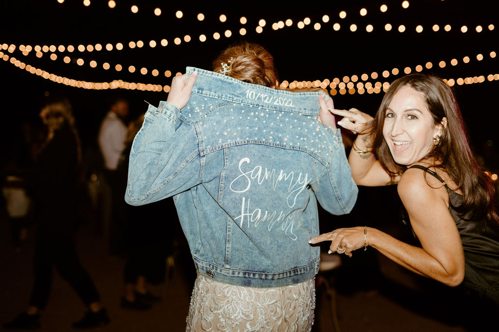 Guest enjoying the brides jean jacket with a cute nick name of her first and last name written on it. 