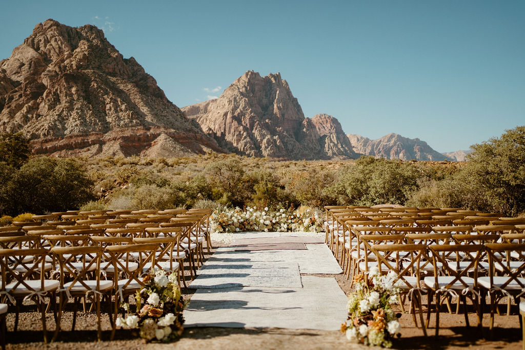 Timeless Red Rock Canyon Wedding ceremony set up. Chairs, walkway and floral ground arch with white and toffee colored roses. 