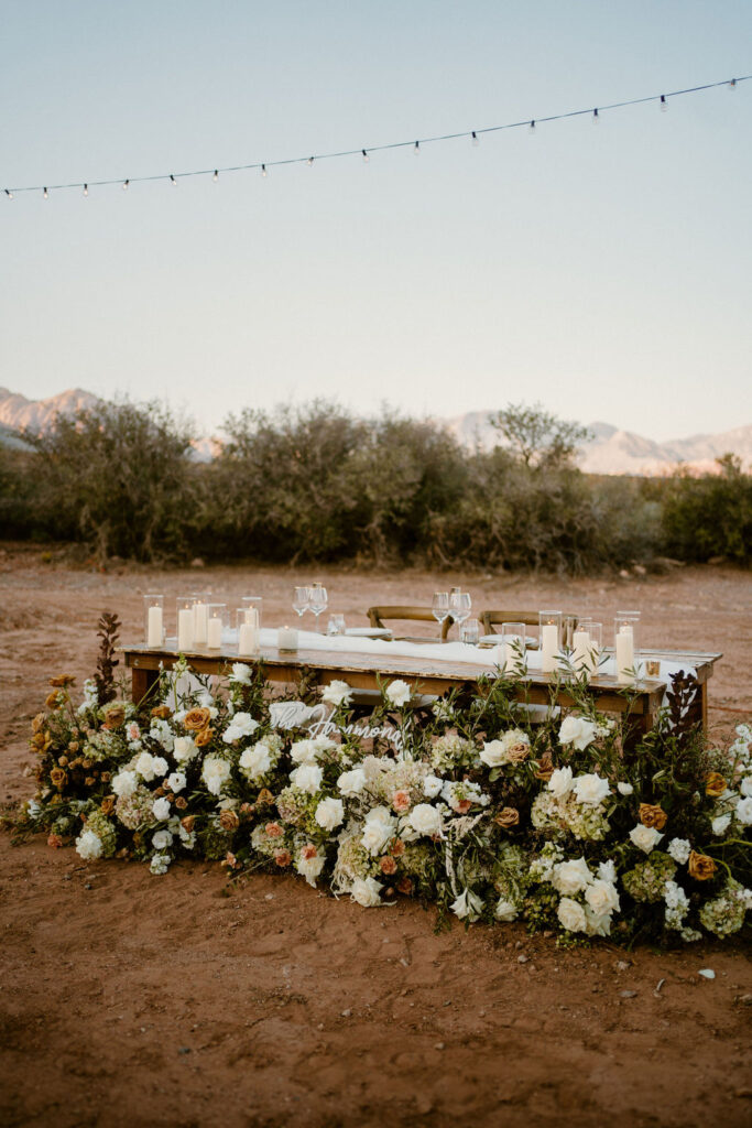 Timeless Red Rock Canyon Wedding with ground floral arch at the His and Her's table. 
