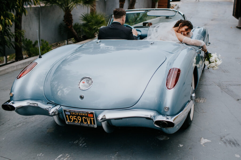 Newlyweds driving off in a vintage car