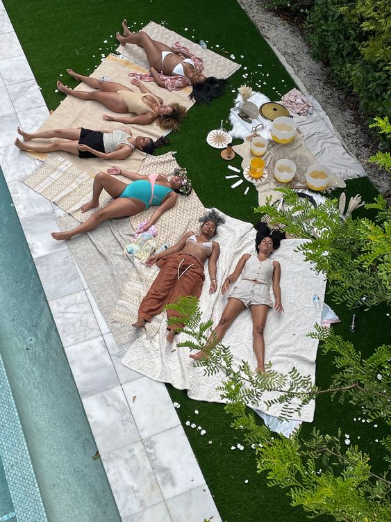 Bachelorette party enjoying a charcuterie board laying out by the pool relaxing. 
