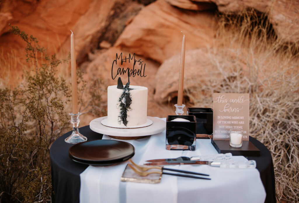 Dark and moody Mr. and Mrs. elopement cake table. Black table cloth, white running and a single tier cake with a unique black marbled effect. 