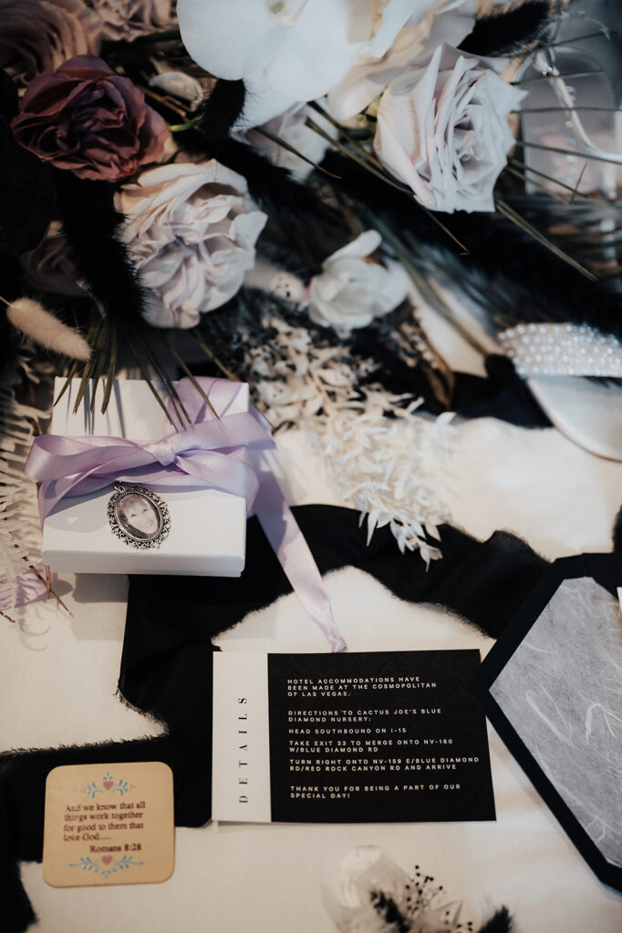Close up of the invitation and bouquet display. A tiny jewelry box wrapped in  a lavender silk bow holding a tiny photo. 