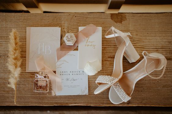 Boho Style Wedding Invitation suite with brides shoes and perfume. 