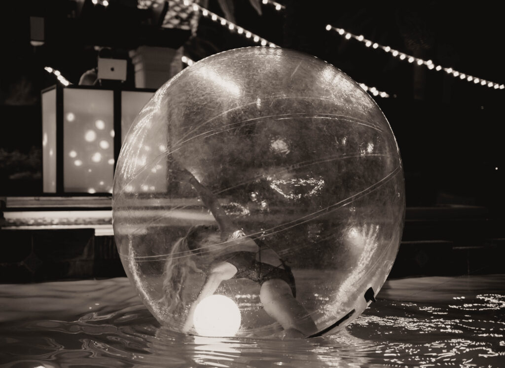 Unveiling the Magic: The Art of Styling a Themed Wedding a dancer inside of a giant blown up bubble on the water. 