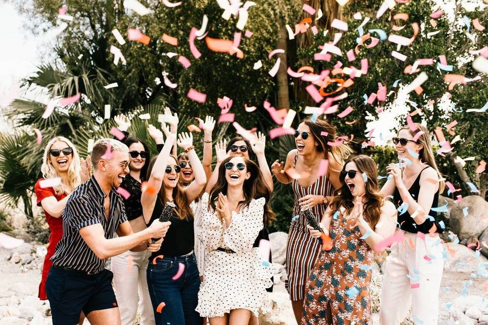 5 Trendiest Bach Party Themes confettie canon going off for a bride as she is surrounded by all of her friends cheering. 