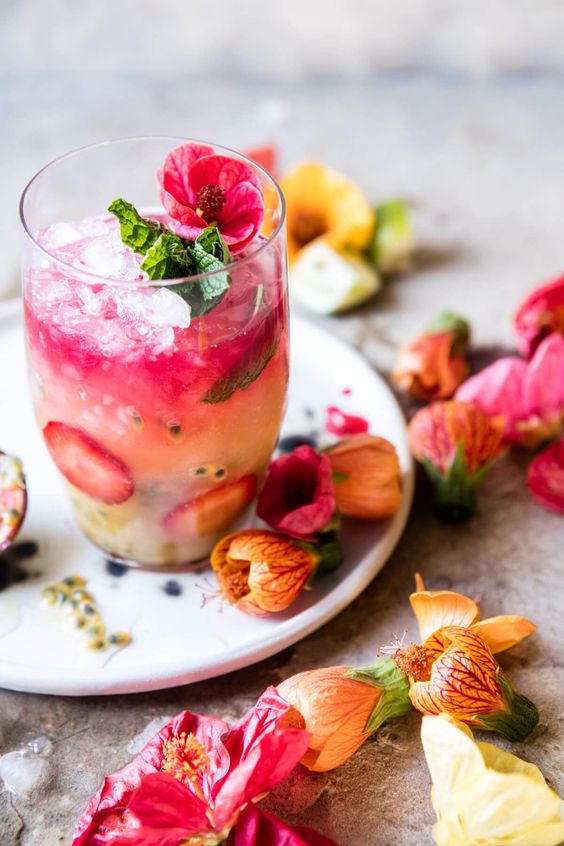 Spring garden party cocktail. With hibiscuses flowers and strawberries. 