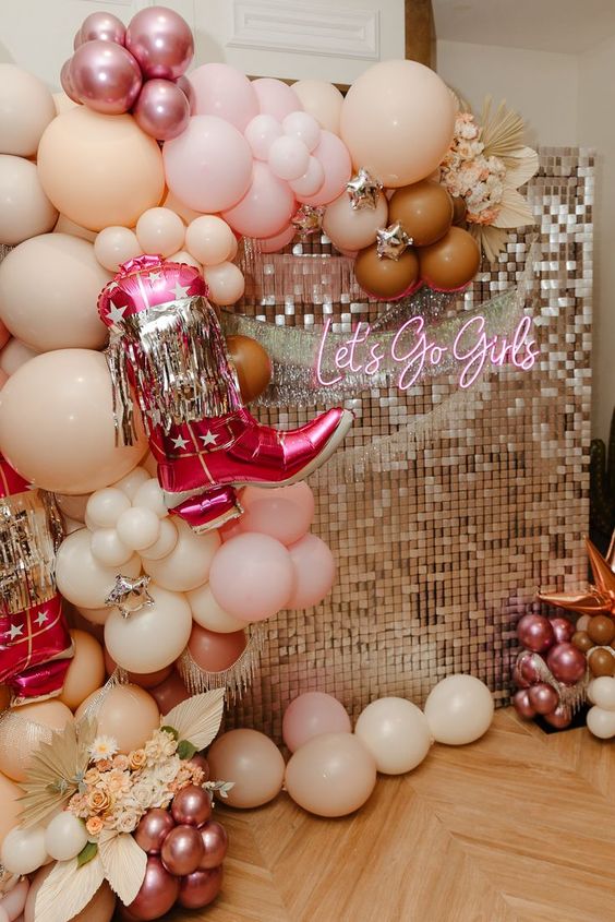 5 Trendiest Bach Party Themes Let's Go Girls neon sign with pink balloon arch with a giant pink cowgirl boot balloon. 