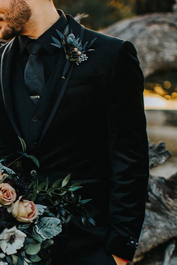 Unveiling the Magic: The Art of Styling a Themed Wedding rich velvet groom attire of all black with a soft blue thistle boutonniere. 