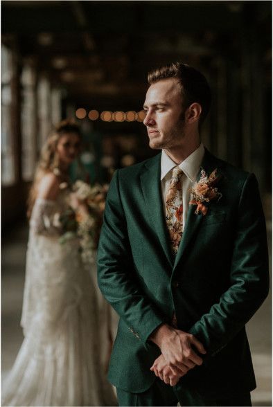 Unveiling the Magic: The Art of Styling a Themed Wedding Groom attire in a rich deep green suit with floral tie.