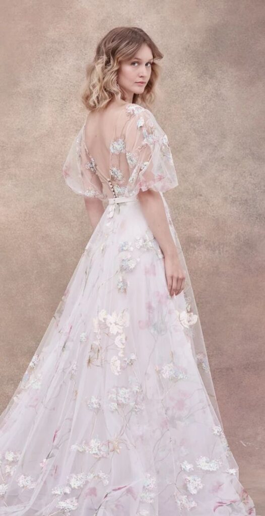 Soft pink tulle wedding dress with embroidered flowers. With an illusion style sleeves and neckline. 