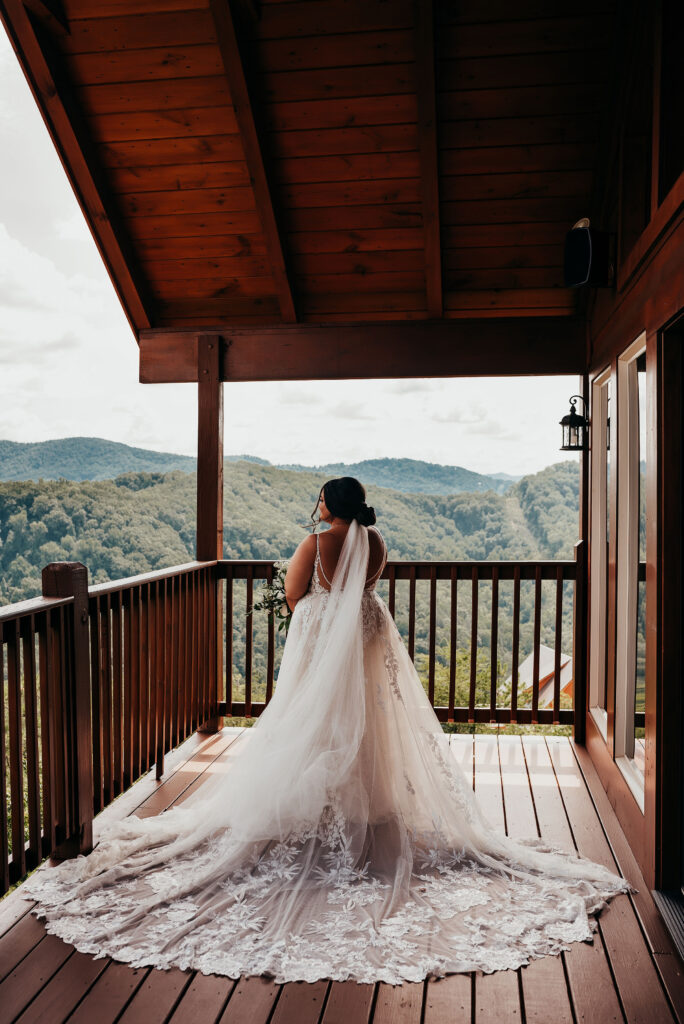 Fun & Creative Wedding Day Photo Poses and Ideas bride looks off at the Tennessee hills. Her long lace veil splayed perfectly behind her. 