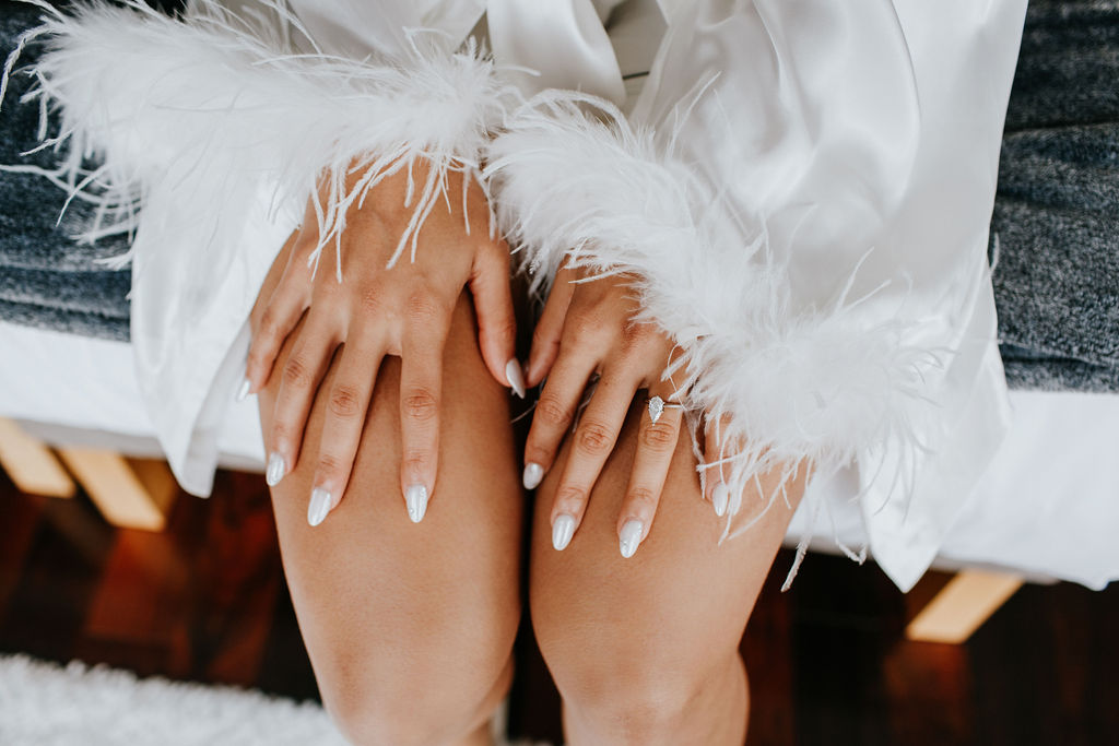 Unleash the Magic: Why Your First Look Should Steal the Show. Bride with manicured nails and feather robe. 