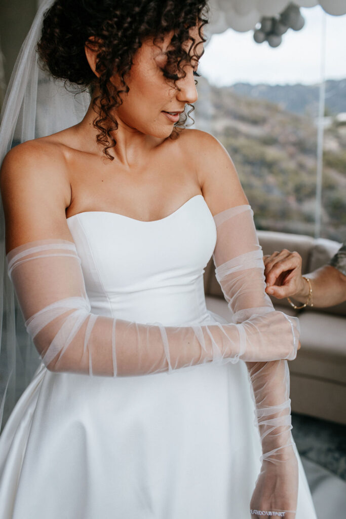 Bride putting on sleeves for wedding