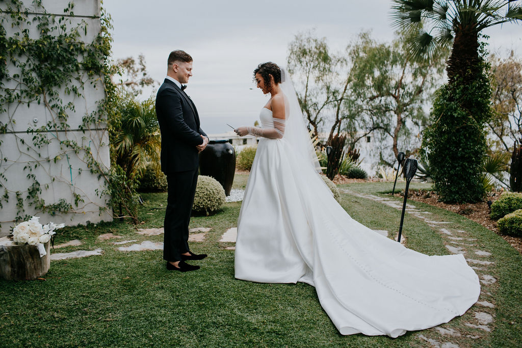 Unleash the Magic: Why Your First Look Should Steal the Show. Bride reading vows to groom during private vow reading 
