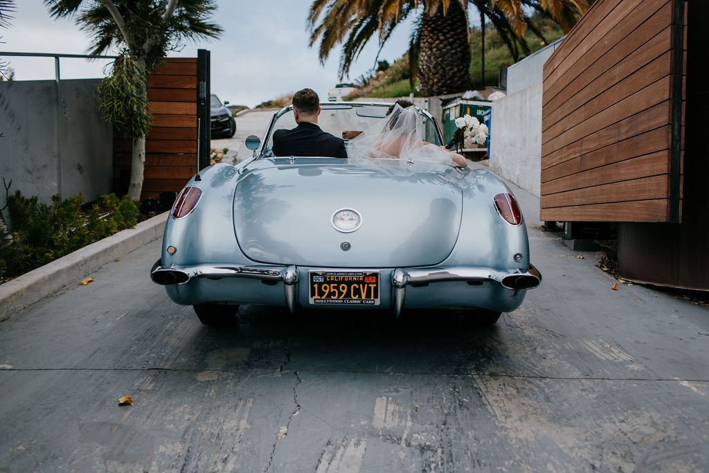 Unleash the Magic: Why Your First Look Should Steal the Show. Bride and groom leaving in classic blue car 