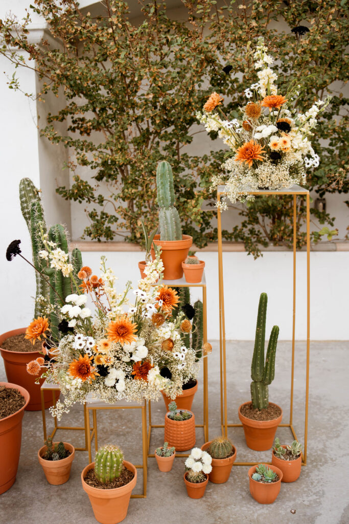a huge display of flowers with pops of orange throughout the design