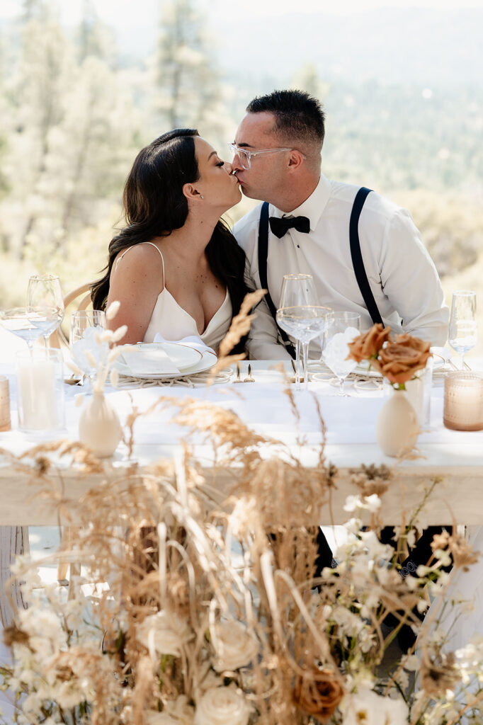 Yosemite Micro-Wedding: Why Intimate Celebrations are a Vibe. Newlyweds kissing at sweetheart table. 