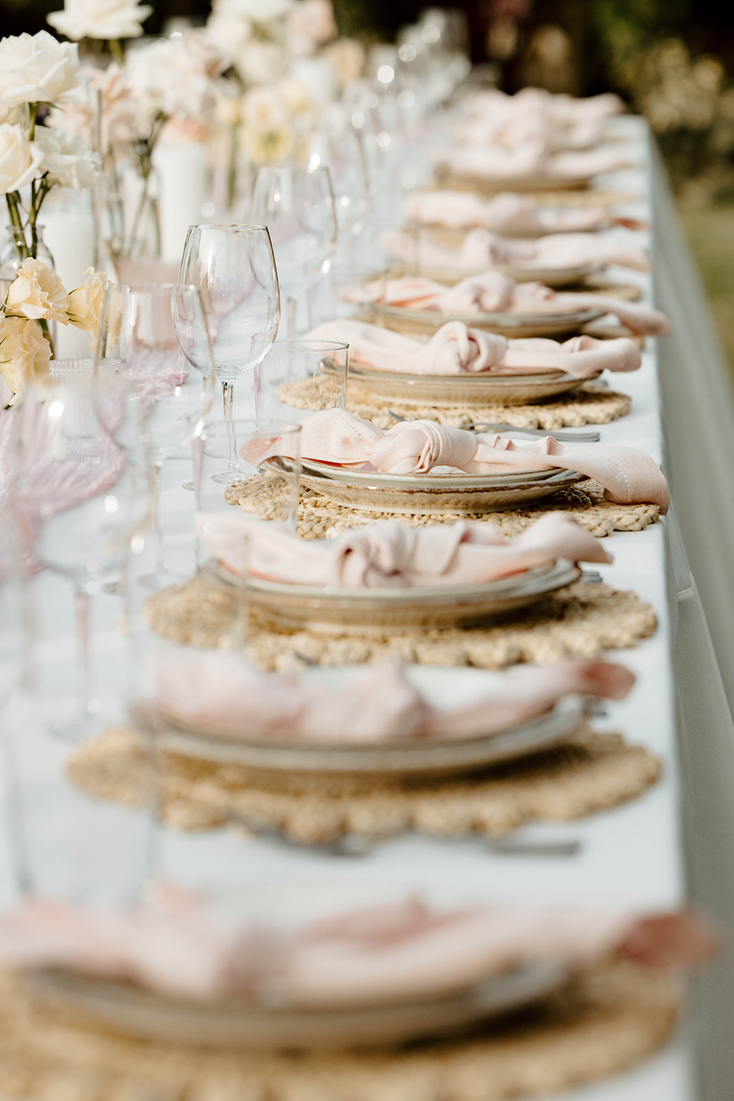 Elegant table setting with pink napkins and rustic plate chargers for a cabo san lucas wedding