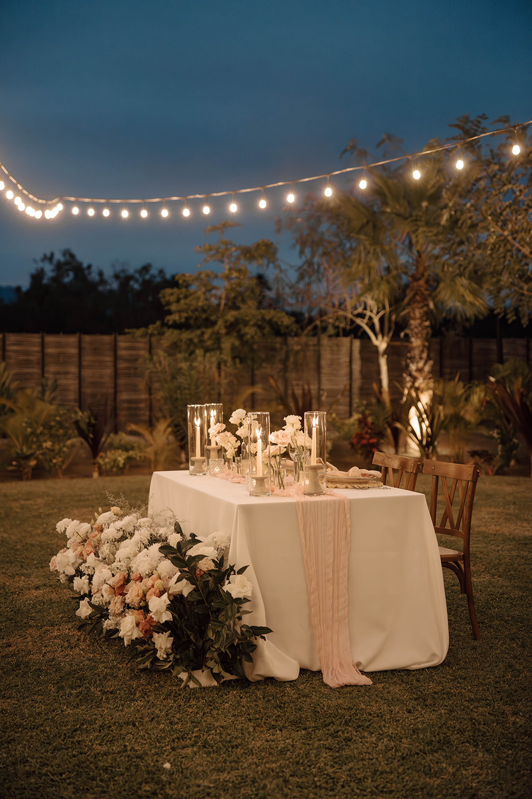 Elegant outdoor dining setup at dusk with string lights and floral decorations at a Cabo San Lucas Wedding