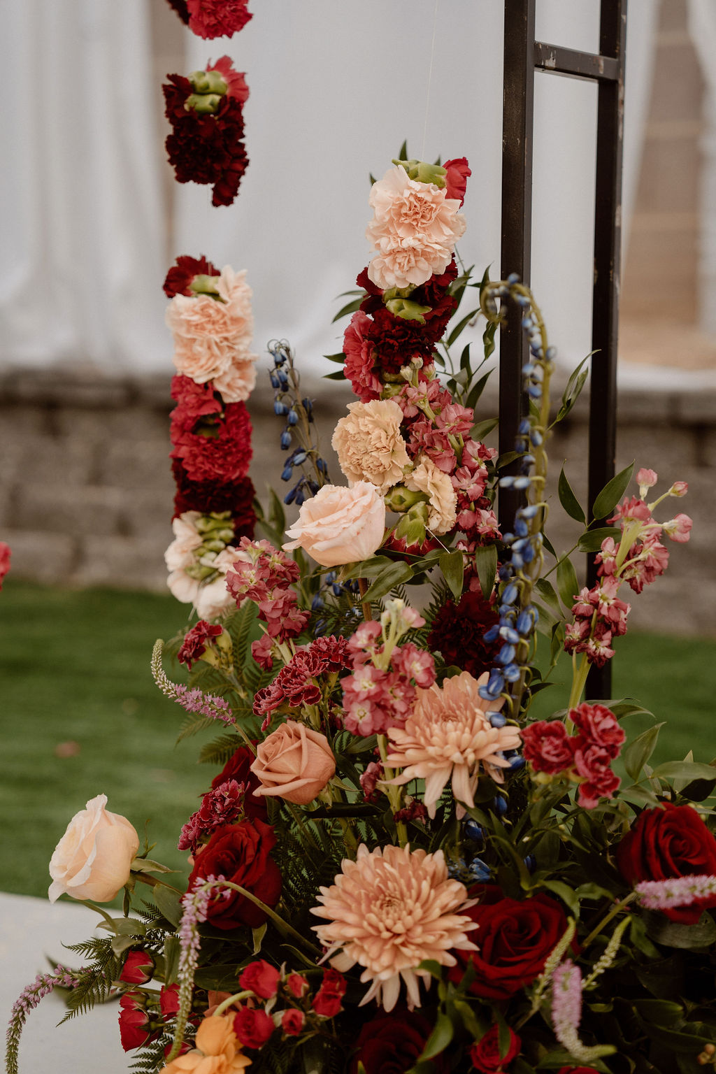 An elegant floral arrangement with roses, chrysanthemums, and other flowers in shades of pink, red, and cream.