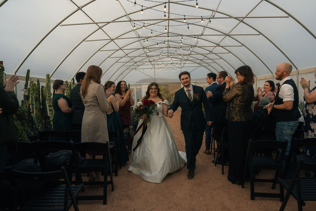 Couple exiting their wedding ceremony as petals are being thrown at Cactus Joe's Nursery