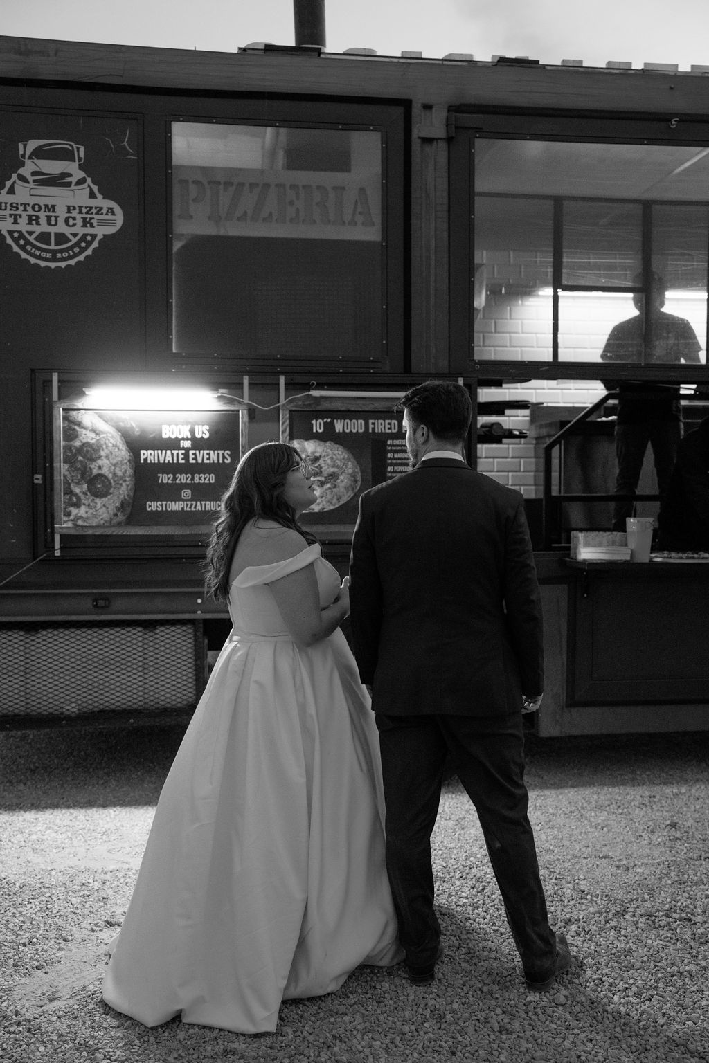 couple at their wedding reception ordering pizza from a truck 