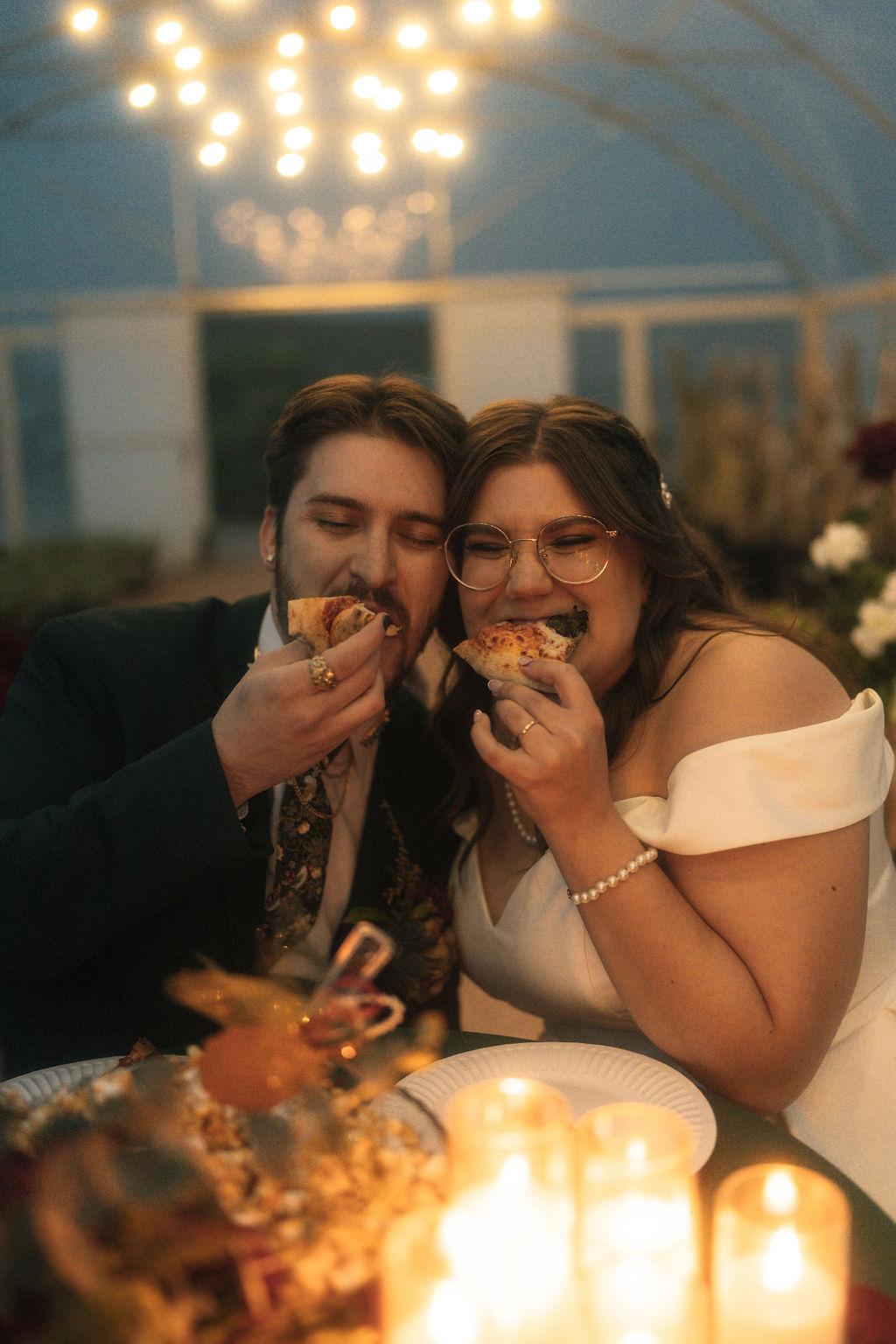 Couple enjoying their wedding and eating pizza during their reception 