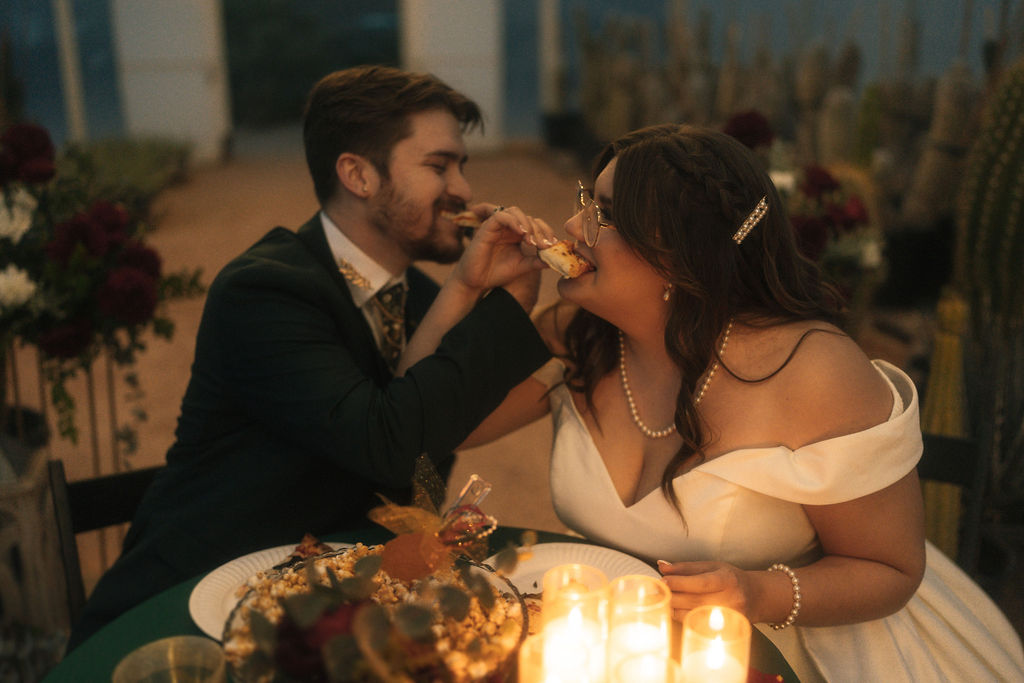 Couple enjoying their wedding and eating pizza during their reception 