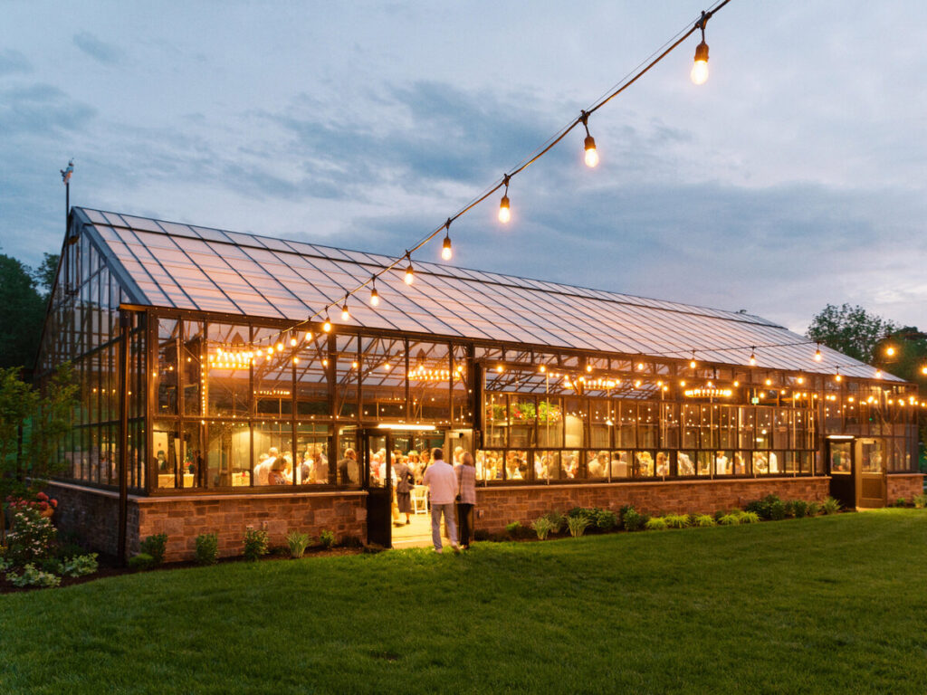 Sunsets on side of greenhouse with many guests inside | Timeless