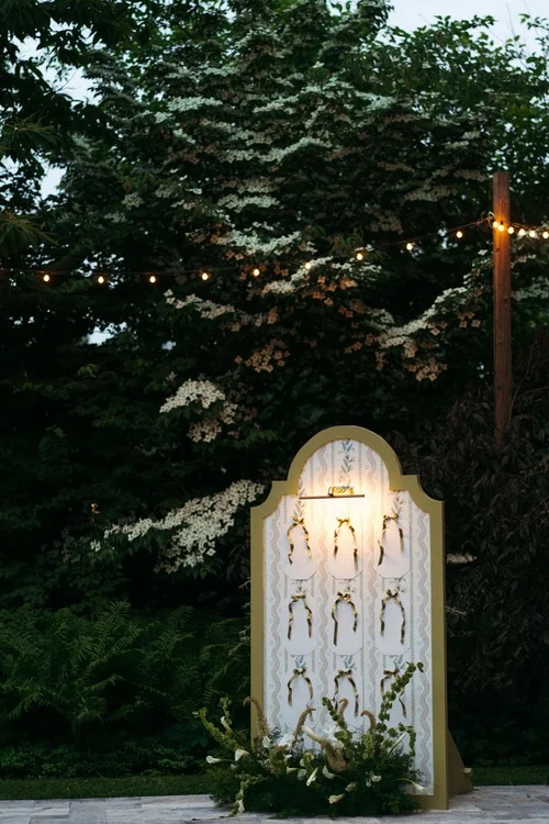 Green and white seat signage infrotn of backdrop of trees