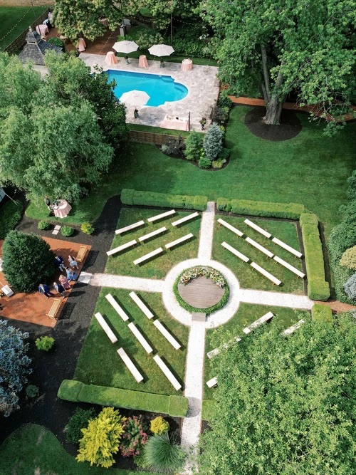 360 ceremony design with wooden circular platform at the center and benches within the garden surrounding