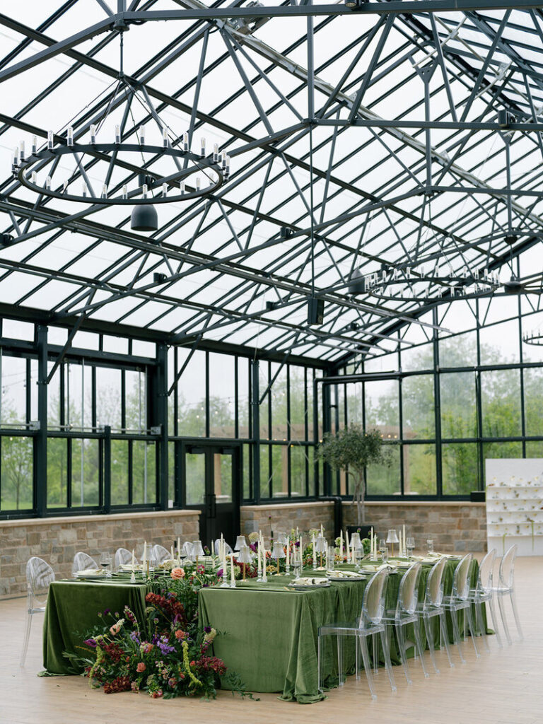 Green house reception with green tablescapes and bright colorful foral arrangements